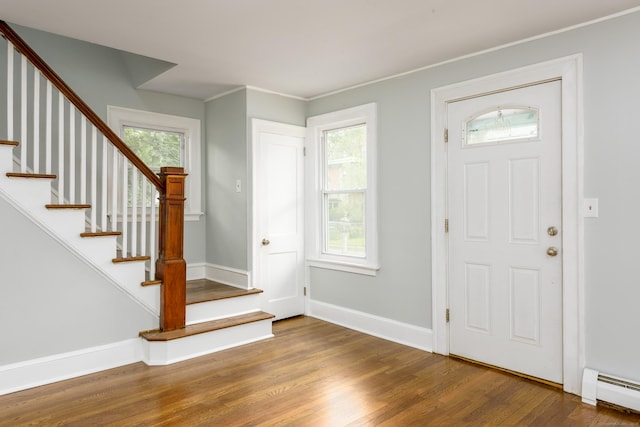 49 Olmsted St, East Hartford, CT 06108 - entryway featuring a baseboard heating unit, wood finished floors, stairway, and crown molding