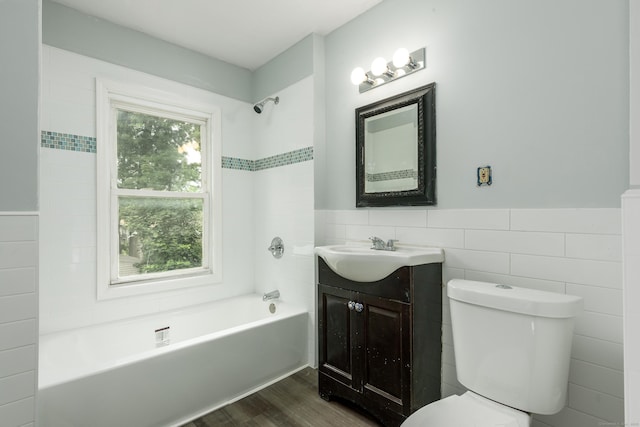 49 Olmsted St, East Hartford, CT 06108 - bathroom with tile walls, vanity, bathtub / shower combination, wood finished floors, and a wainscoted wall