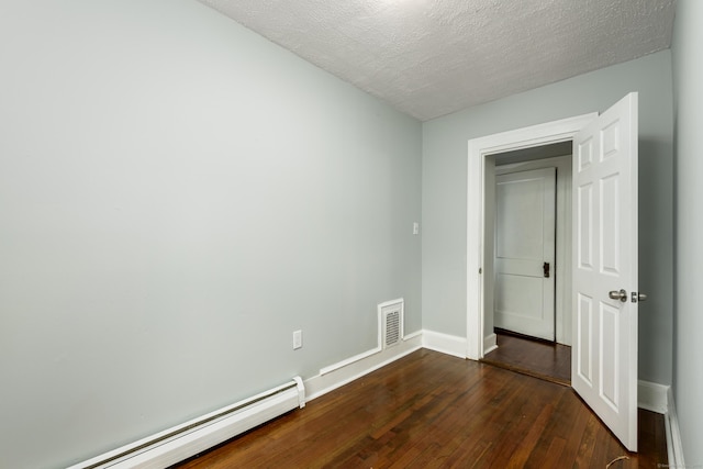 49 Olmsted St, East Hartford, CT 06108 - empty room with a baseboard heating unit, dark wood finished floors, and a textured ceiling