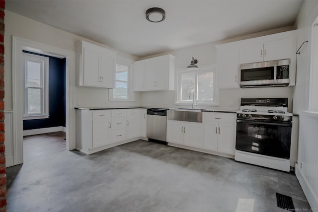 103 Clay St, Thomaston, CT 06787 - kitchen featuring appliances with stainless steel finishes, white cabinetry, and concrete floors
