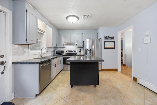 489 Thomaston Rd, Watertown, CT 06795 - kitchen with stainless steel appliances, dark countertops, baseboard heating, tasteful backsplash, and under cabinet range hood