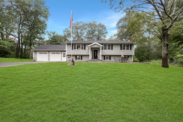 489 Thomaston Rd, Watertown, CT 06795 - bi-level home featuring a garage, driveway, a front lawn, and a chimney