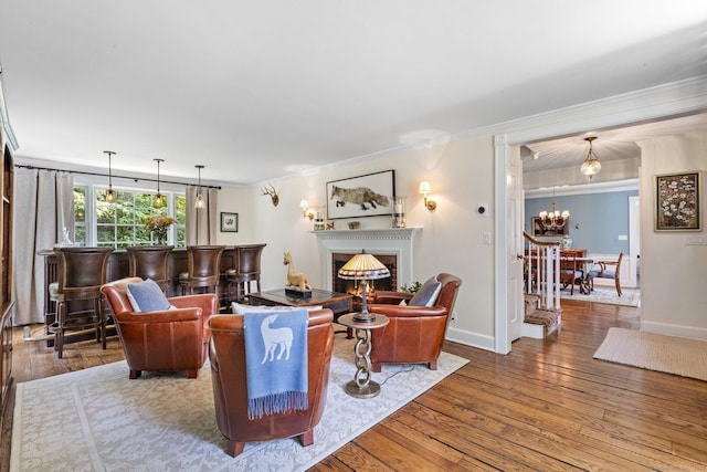 5 Lookout Rd, Norwalk, CT 06850 - living room featuring ornamental molding, wood-type flooring, a chandelier, and a warm lit fireplace