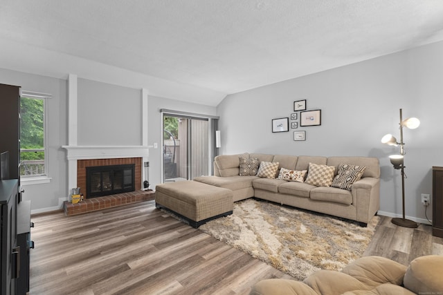 21 Heritage Cir Unit A, Southbury, CT 06488 - living area with wood finished floors, healthy amount of natural light, a brick fireplace, and vaulted ceiling
