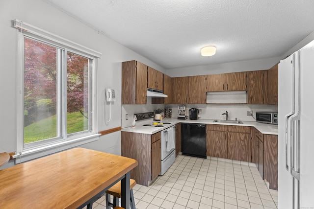 21 Heritage Cir Unit A, Southbury, CT 06488 - kitchen with white appliances, brown cabinetry, under cabinet range hood, a textured ceiling, and light countertops