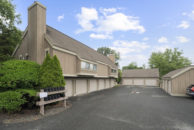 21 Heritage Cir Unit A, Southbury, CT 06488 - view of asphalt driveway with community garages