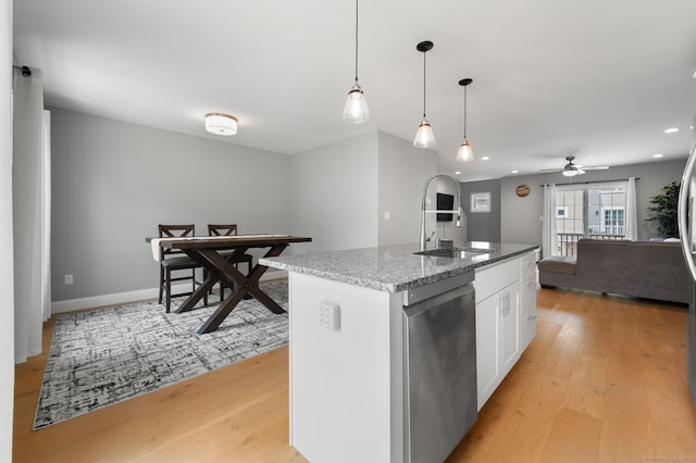 64 Scotch Cap Rd Unit 173, Waterford, CT 06375 - kitchen with stainless steel dishwasher, open floor plan, light wood finished floors, white cabinetry, and stone counters