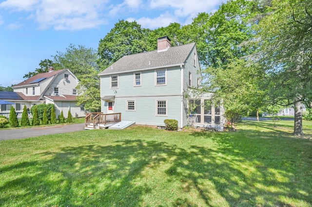 133 Griswold Rd, Wethersfield, CT 06109 - rear view of property featuring a chimney, a deck, a sunroom, and a yard