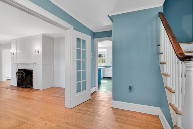 133 Griswold Rd, Wethersfield, CT 06109 - unfurnished living room featuring light wood-style floors, stairway, a fireplace, and crown molding