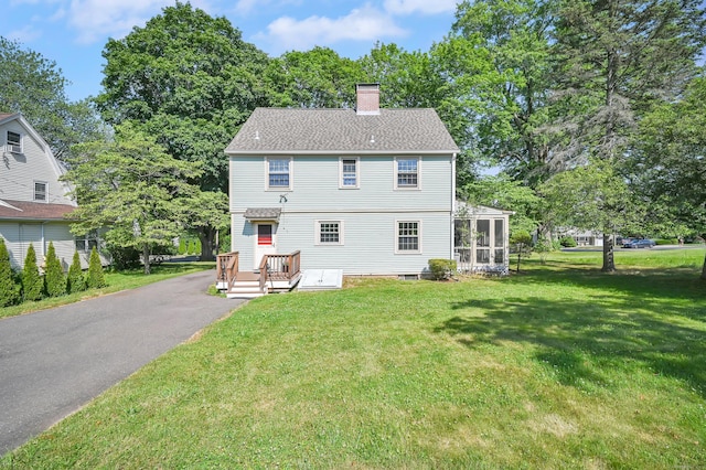 133 Griswold Rd, Wethersfield, CT 06109 - back of house featuring a chimney, a yard, a sunroom, and asphalt driveway
