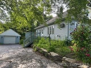 1063 N Main St, Killingly, CT 06241 - view of home's exterior featuring an outbuilding, a detached garage, and asphalt driveway