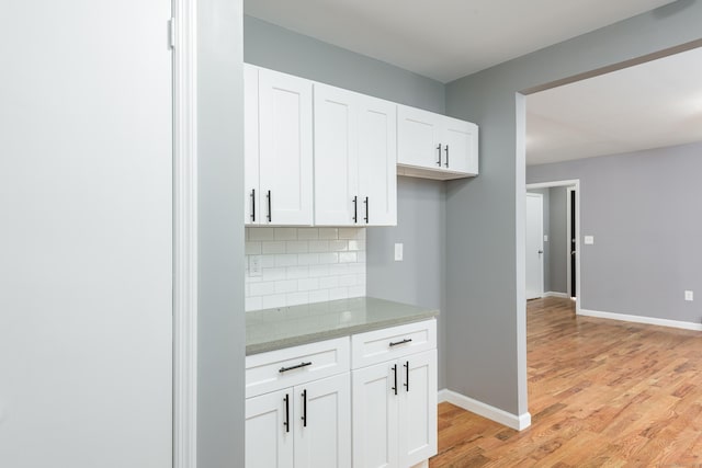 68 School St, Hartford, CT 06106 - kitchen with decorative backsplash, light wood-style floors, light stone counters, and white cabinetry
