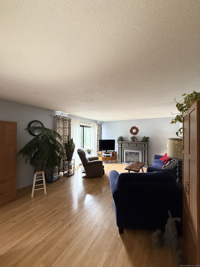 13 Heritage Vlg Unit E, Southbury, CT 06488 - living area featuring a textured ceiling, light wood finished floors, and a glass covered fireplace