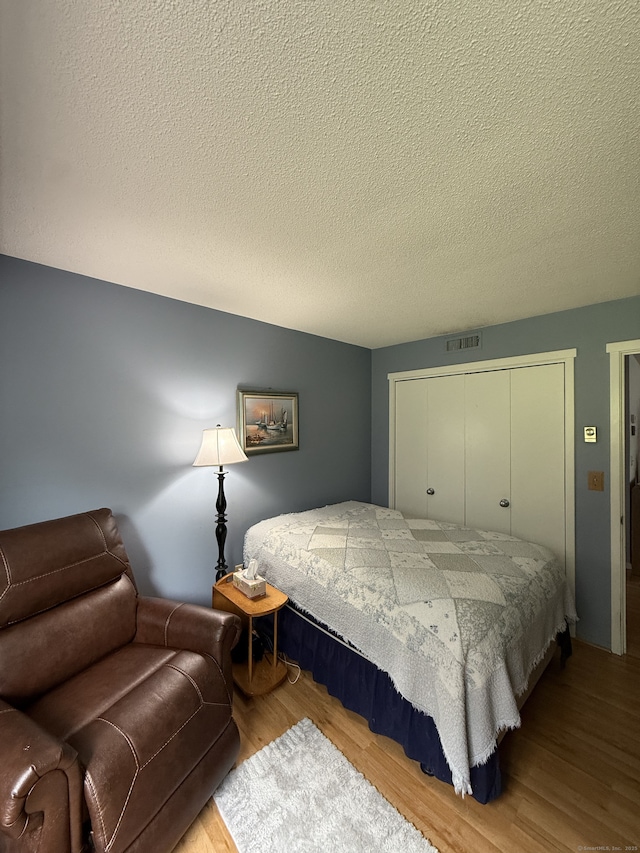 13 Heritage Vlg Unit E, Southbury, CT 06488 - bedroom featuring wood finished floors, a closet, and a textured ceiling