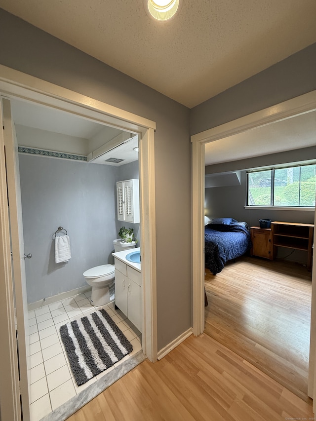 13 Heritage Vlg Unit E, Southbury, CT 06488 - bathroom with vanity, wood finished floors, and a textured ceiling