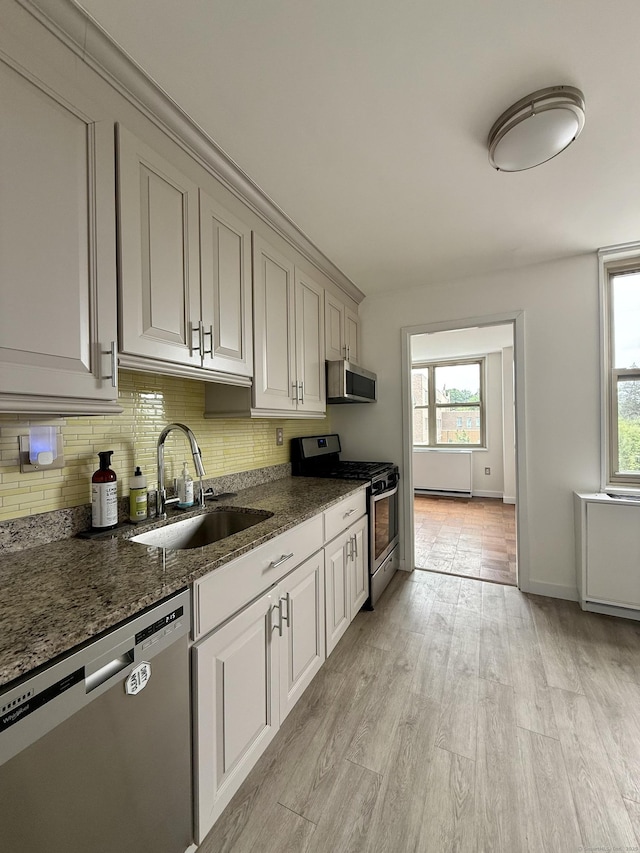 1 Strawberry Hill Ct Apt 2D, Stamford, CT 06902 - kitchen featuring stainless steel appliances, healthy amount of natural light, decorative backsplash, and dark stone countertops