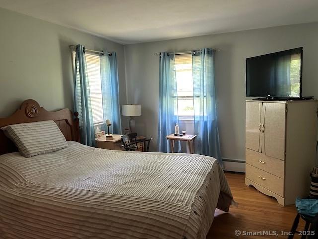 450 Toll Gate Rd, Groton, CT 06340 - bedroom featuring wood finished floors, multiple windows, and a baseboard radiator