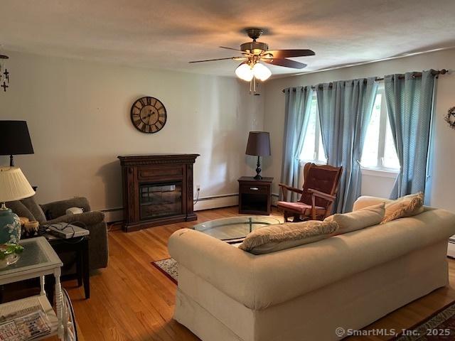 450 Toll Gate Rd, Groton, CT 06340 - living room with baseboard heating, ceiling fan, light wood-style floors, and a glass covered fireplace