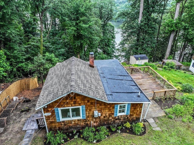 69 Forest Dr, Newtown, CT 06482 - rear view of property featuring a storage unit, roof with shingles, and a chimney