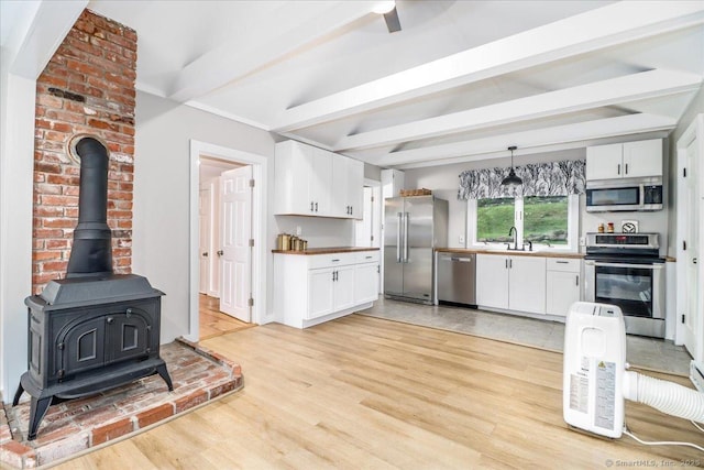 69 Forest Dr, Newtown, CT 06482 - kitchen featuring stainless steel appliances, beamed ceiling, light wood-style flooring, white cabinetry, and decorative light fixtures