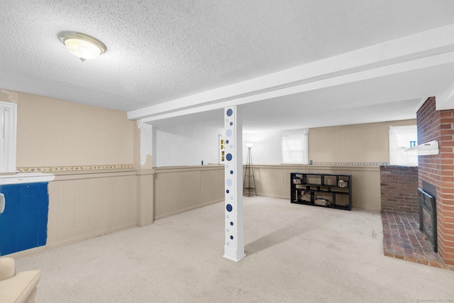 24 Cambridge Dr, Southington, CT 06489 - below grade area featuring carpet flooring, a textured ceiling, a fireplace, and wainscoting
