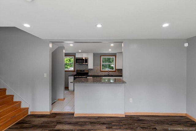 29 Pembroke Rd, Hamden, CT 06514 - kitchen with stainless steel appliances, white cabinets, recessed lighting, dark stone counters, and light wood finished floors
