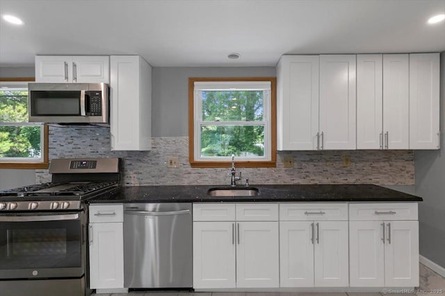 29 Pembroke Rd, Hamden, CT 06514 - kitchen with appliances with stainless steel finishes, dark stone counters, decorative backsplash, white cabinetry, and recessed lighting