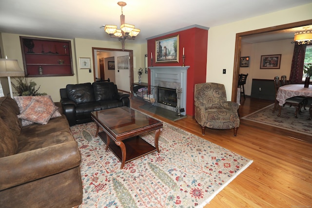 21 Berle Rd, South Windsor, CT 06074 - living room with a chandelier, wood finished floors, and a fireplace with raised hearth