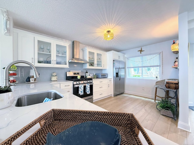 5 Mansfield Grove Rd Apt 146, East Haven, CT 06512 - kitchen featuring appliances with stainless steel finishes, wall chimney range hood, white cabinetry, tasteful backsplash, and glass insert cabinets