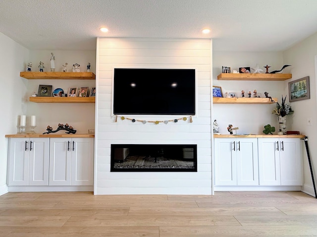 5 Mansfield Grove Rd Apt 146, East Haven, CT 06512 - unfurnished living room with light wood-style floors, a large fireplace, recessed lighting, and a textured ceiling