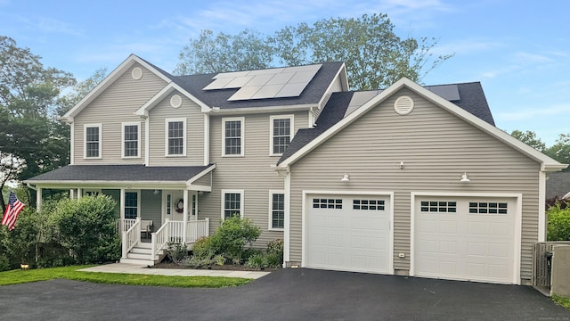 13 Spruce Ridge Dr, New Fairfield, CT 06812 - view of front of home featuring asphalt driveway, a garage, covered porch, roof mounted solar panels, and roof with shingles