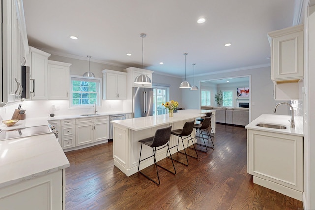 13 Spruce Ridge Dr, New Fairfield, CT 06812 - kitchen featuring stainless steel appliances, open floor plan, a breakfast bar area, healthy amount of natural light, and ornamental molding