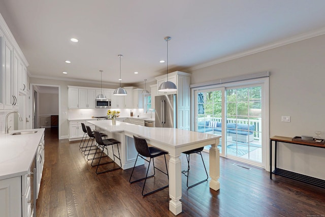 13 Spruce Ridge Dr, New Fairfield, CT 06812 - kitchen featuring stainless steel appliances, a kitchen breakfast bar, crown molding, dark wood finished floors, and white cabinetry