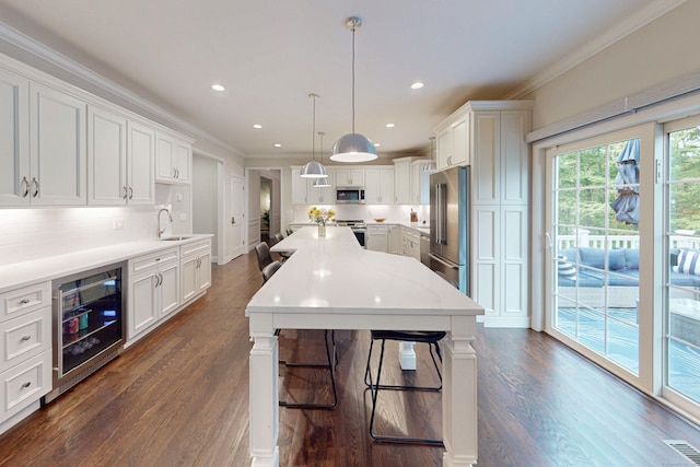 13 Spruce Ridge Dr, New Fairfield, CT 06812 - kitchen with wine cooler, appliances with stainless steel finishes, crown molding, light countertops, and white cabinets