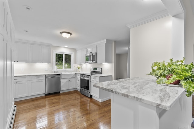 14 Pine Tree Ln, Avon, CT 06001 - kitchen featuring stainless steel appliances, a baseboard heating unit, white cabinets, wood finished floors, and crown molding