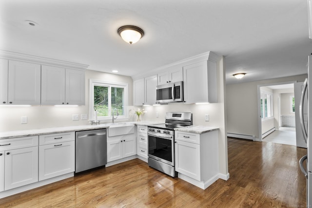 14 Pine Tree Ln, Avon, CT 06001 - kitchen featuring appliances with stainless steel finishes, a baseboard heating unit, white cabinetry, light wood finished floors, and recessed lighting