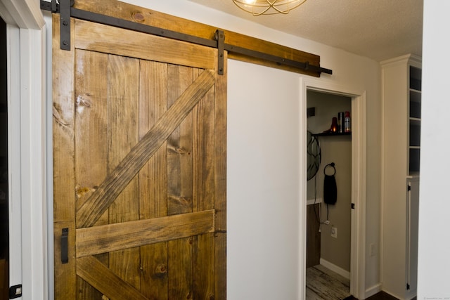 6 Weymouth Dr, Enfield, CT 06082 - detailed view of a barn door, a textured ceiling, and wood finished floors