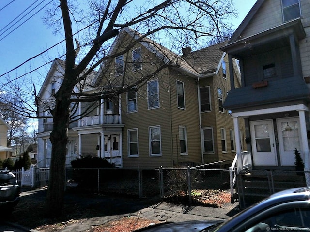 134 Lombard St, New Haven, CT 06513 - view of side of property featuring a fenced front yard, a chimney, and a gate