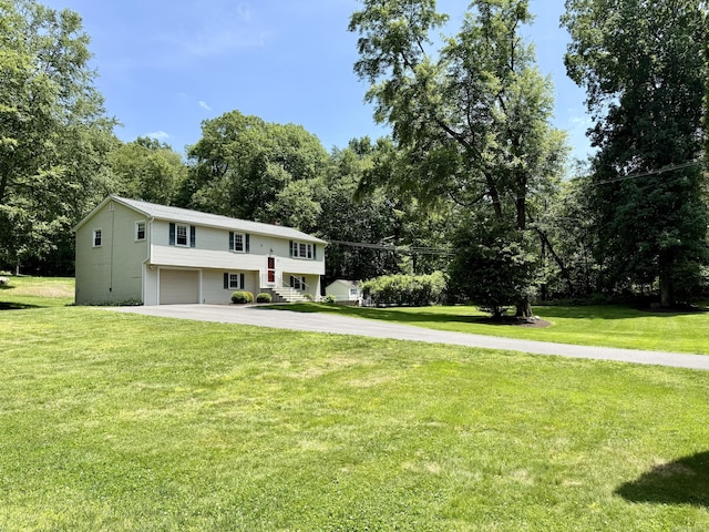 37 Pine Hill Rd, Tolland, CT 06084 - split foyer home featuring an attached garage, asphalt driveway, a front yard, and view of wooded area