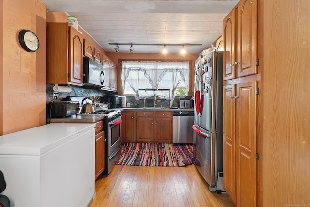 283 Third Ave, West Haven, CT 06516 - kitchen with appliances with stainless steel finishes, light wood-type flooring, brown cabinetry, rail lighting, and decorative backsplash