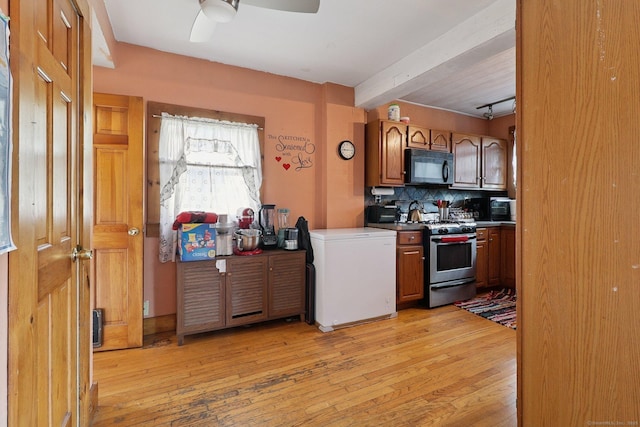 283 Third Ave, West Haven, CT 06516 - kitchen with black microwave, stainless steel gas range oven, beam ceiling, fridge, and light wood-type flooring