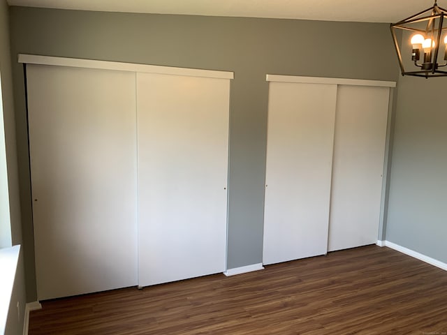 158 Webster Ct Unit 158, Newington, CT 06111 - unfurnished bedroom featuring a chandelier, dark wood-style floors, and multiple closets