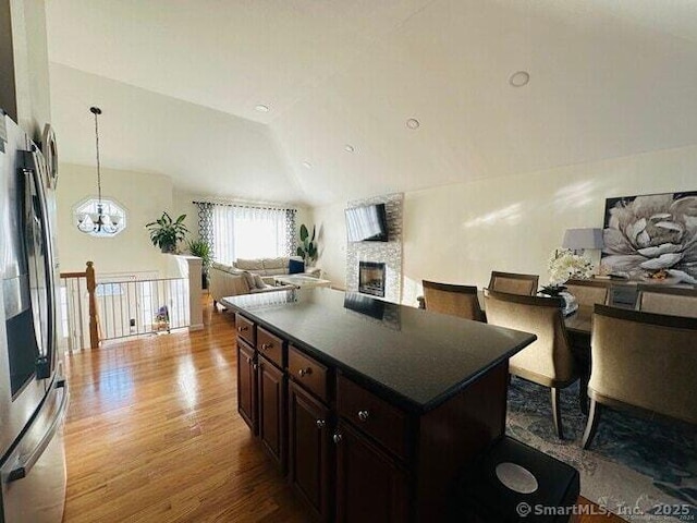 470 Nott St, Wethersfield, CT 06109 - kitchen with wood finished floors, dark countertops, stainless steel refrigerator, a fireplace, and open floor plan