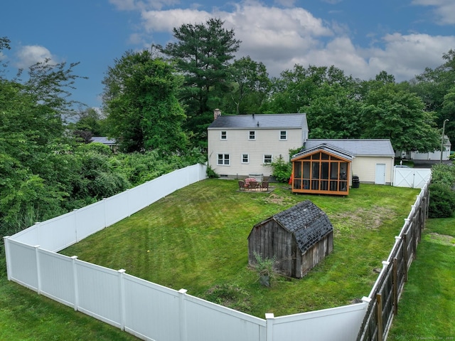 17 Plainfield St, Enfield, CT 06082 - rear view of house with a sunroom, a fenced backyard, a chimney, and a storage unit