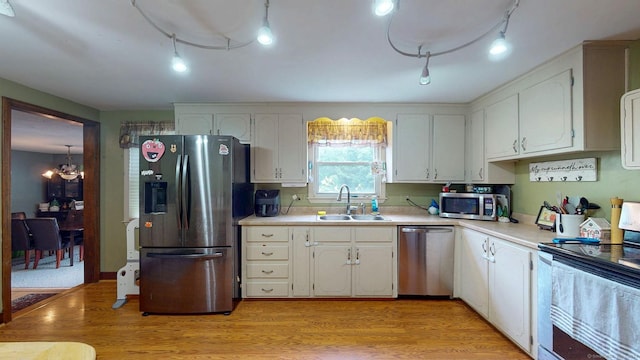17 Plainfield St, Enfield, CT 06082 - kitchen with stainless steel appliances, a chandelier, track lighting, and white cabinetry