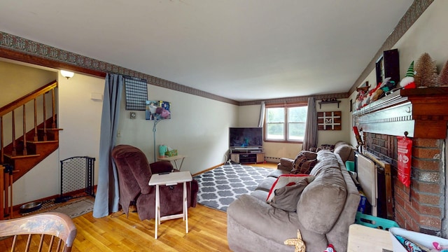 17 Plainfield St, Enfield, CT 06082 - living room featuring a brick fireplace, stairs, and wood finished floors