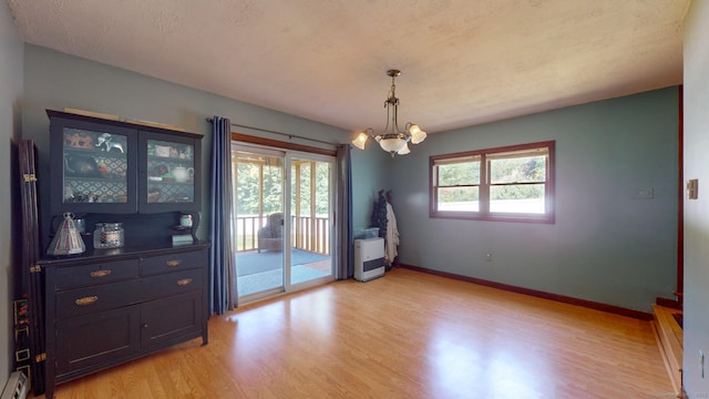 17 Plainfield St, Enfield, CT 06082 - unfurnished dining area featuring light wood-style flooring, a chandelier, and a baseboard heating unit