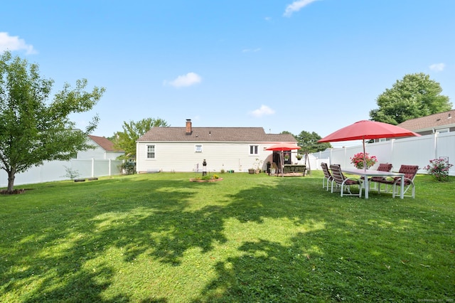 529 Orchard St, Rocky Hill, CT 06067 - rear view of property featuring a fenced backyard, a chimney, and outdoor dining space