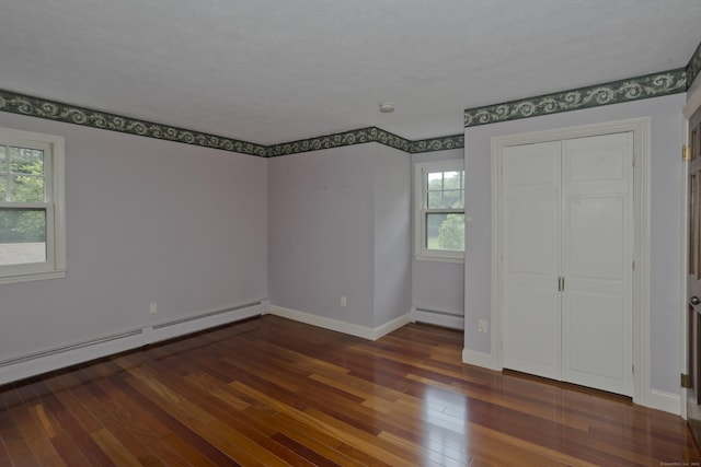 317 Turnpike Rd, Somers, CT 06071 - unfurnished bedroom featuring a baseboard heating unit, hardwood / wood-style floors, and a closet