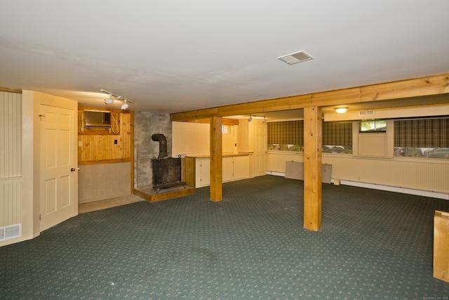 317 Turnpike Rd, Somers, CT 06071 - finished below grade area featuring a wood stove, carpet flooring, a baseboard radiator, an AC wall unit, and wooden walls